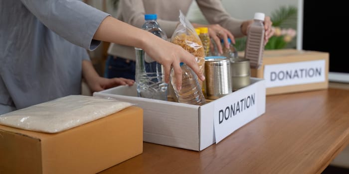 Volunteer preparing free foodstuff rations for poor people. Charity two woman of the community work together. concept of giving and humanitarian aid.