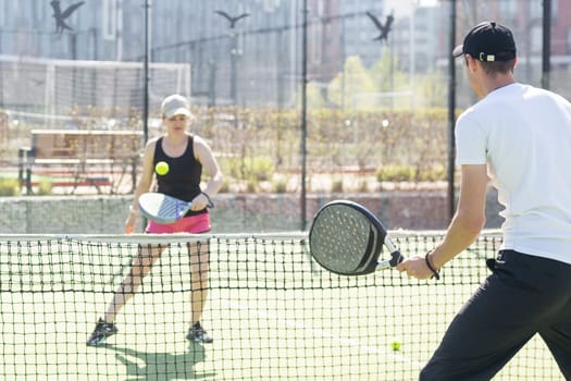 Young sporty woman and man playing padel together on same team. High quality photo