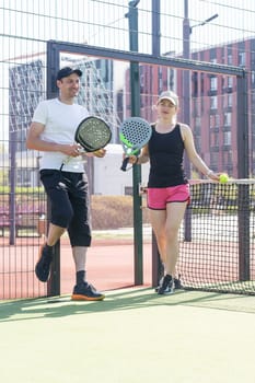 Young sporty woman and man playing padel together on same team. High quality photo