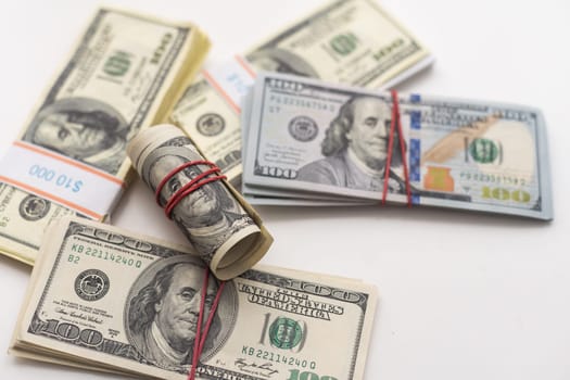 A bankroll of 100 bills on top of a pile of cash. High quality photo
