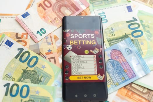 dollars and euros, smartphone with sports bet application. High quality photo