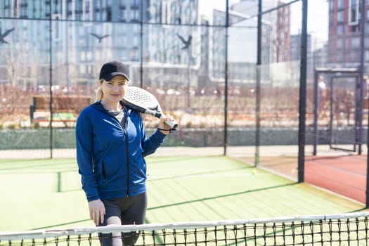 Determined sporty young woman playing padel in court. High quality photo