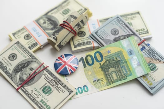 Cash money close up, top view. A bundle of 100 dollar bills lies on a pile of banknotes of various countries (dollars, euros, rubles). High quality photo