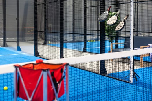 Paddle tennis rackets, balls and basket in court still life. High quality photo