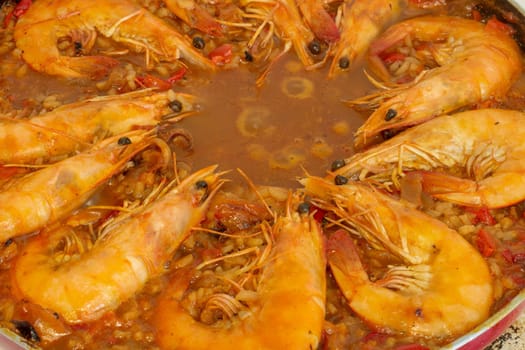 Experience culinary harmony as golden-fried shrimp rejoins the vibrant medley of flavors in the traditional Spanish paella, enriching each bite with savory delight