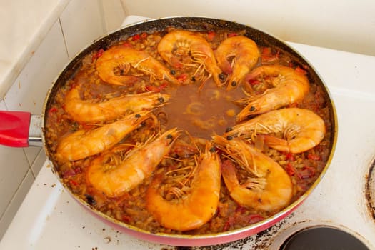 Experience culinary harmony as golden-fried shrimp rejoins the vibrant medley of flavors in the traditional Spanish paella, enriching each bite with savory delight