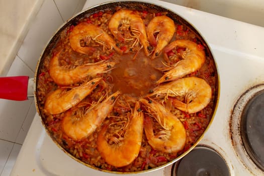 Experience culinary harmony as golden-fried shrimp rejoins the vibrant medley of flavors in the traditional Spanish paella, enriching each bite with savory delight