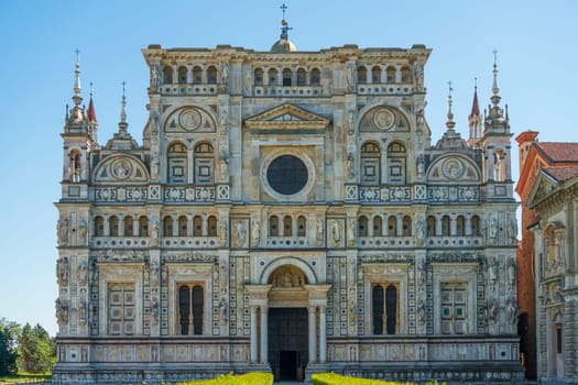 Front view of Certosa di Pavia monastery close up,historical monumental complex that includes a monastery and a sanctuary.The Ducale Palace on the right,Pavia,Italy.