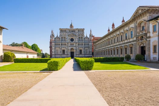 Panorama view of Certosa di Pavia monastery,historical monumental complex that includes a monastery and a sanctuary and green court.The Ducale Palace on the right,Pavia,Italy.