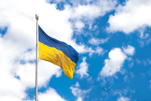 beautiful colored national flag of Ukraine on textured fabric, concept of emigration, politics and war in Ukraine. Ukrainian flags on transparent background of the sky. symbols. independent country
