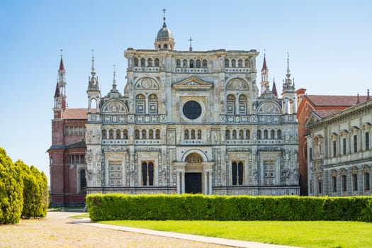 Certosa di Pavia monastery, historical monumental complex that includes a monastery and a sanctuary. green court and a church.The Ducale Palace on the right,Pavia,Italy.