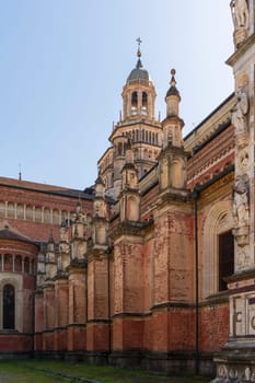 Left side view of Certosa di Pavia monastery, historical monumental complex that includes a monastery and a sanctuary. green court and a church, Pavia, Italy.