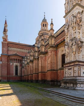 Left side view of Certosa di Pavia monastery, historical monumental complex that includes a monastery and a sanctuary. green court and a church, Pavia, Italy.