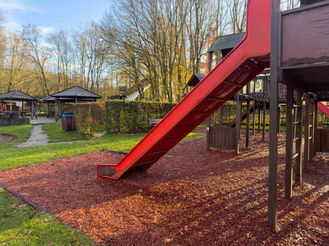 Colorful playground with climbing stairs and slides on yard in the park.