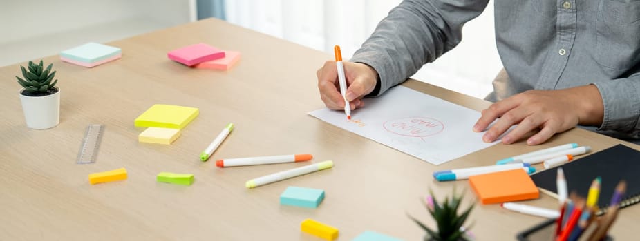 Skilled businessman brainstorms marketing ideas using mind maps. Successful male startup leader drafts financial plan on table with sticky notes scatter around. Closeup. Focus on hand.Variegated.