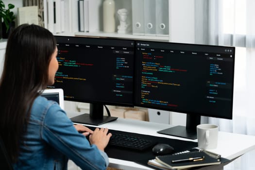 Young Asian in IT developer creating with typing online information on pc with coding program data of website application, wearing jeans shirt. surrounded by safety analysis two screens. Stratagem.