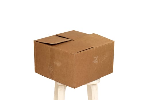 Rectangle cardboard box on beige stool for creative arts and toy storage.