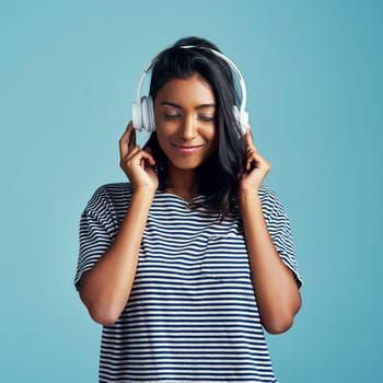Woman, studio and headphones with happy music, listening and streaming podcast for calm with gen z. Radio audio, technology for song entertainment with sound, Indian female person on background.