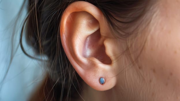 A close up of a woman's ear with two small studs