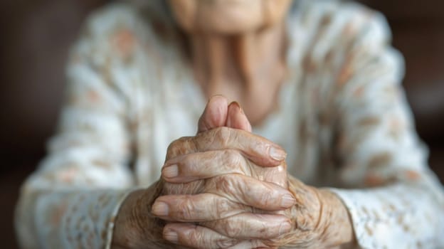 An old woman with hands folded in prayer on a table