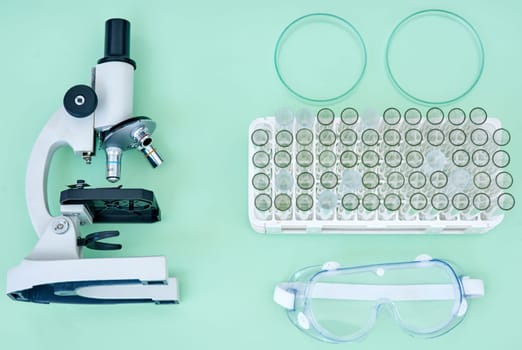 Lab, tools and collection of equipment with microscope, test tube and safety goggles for medical research. Science, medicine and laboratory supplies for pharmaceutical study on studio background