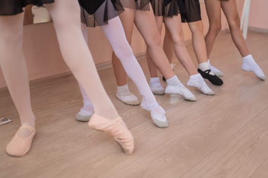 Close-up of feet of 5 little girls and teacher at ballet class