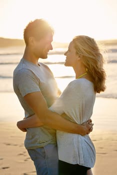 Lens flare, sunset and hug of couple at beach, ocean and sea with affection, bonding and love in summer. People, partners and romance for care together on vacation, holiday and travel in Australia.
