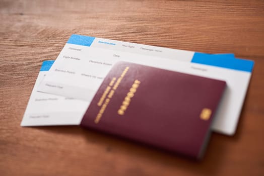 Travel, ticket and passport in house for adventure, journey or immigration on brown background. Flight, identity and visa for opportunity, vacation and boarding pass documents for airport compliance.
