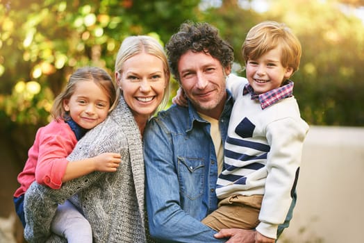 Family, portrait and together in garden for love with cute kids, happiness and lens flare. Parents, young children and face with smile in backyard for weekend with hugging, relax and relationship.