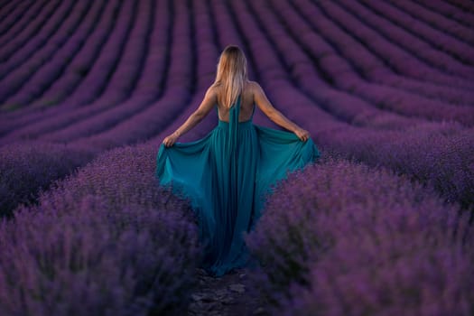 Back view woman lavender sunset. Happy woman in green dress holds lavender bouquet. Aromatherapy concept, lavender oil, photo session in lavender.