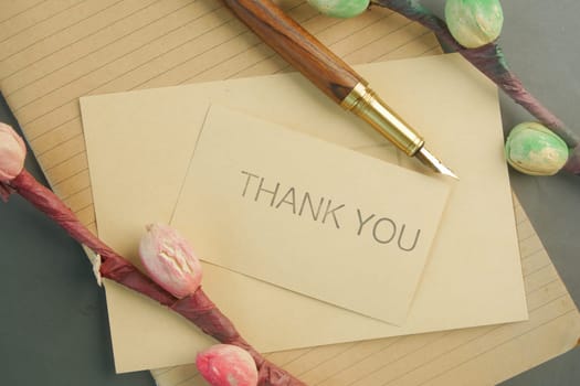 thank you message and envelope on wooden table.