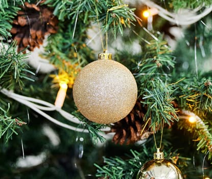 Ball, glitter and lights with Christmas tree for decoration, festive or holiday season at home. Closeup of ornament, sparkle or hanging bauble for decor, December celebration or new year preparation.