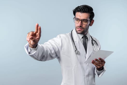 Caucasian smart doctor pointing finger while standing at white background and wearing lab coat. Skilled specialist doctor using medical technology while pointing and holding health data. Deviation.