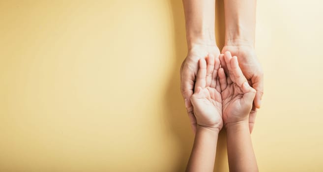 Top view of family hands stacked isolated background. Parents and kid hold empty space a gesture of support and love on Family and Parents Day. Concept of togetherness and trust.