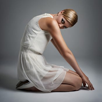 Portrait, woman and ballet in dress at studio on isolated white background, kneeling and makeup for performance. Female person, dancer and performer or artist with practice for concert with fashion.