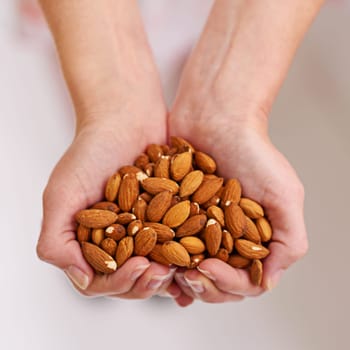 Woman, hands and almonds as fruit of vegetarian for health, wellness and balanced diet with nutrition snacks for farming. Person, fibre and natural vitamin with protein for digestion or weight loss.