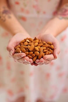 Bunch, almond and nuts in woman hands as a vegetarian for healthy, organic and balanced diet by eating nutritious snacks. Person, fresh and natural ingredients with vitamin from vegan nutrition.