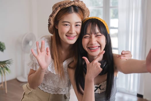 Two women are smiling and posing for a picture. One of them is wearing a hat and the other is wearing a yellow headband