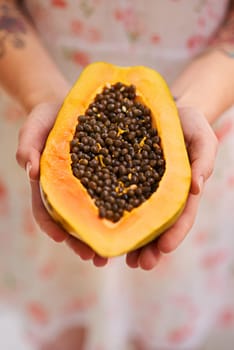 Hands, person and papaya in half with nutrition for healthy eating with seeds, nutrients and wellness. Food, pawpaw and diet with fruit for weight loss with vitamin c for balance with freshness.