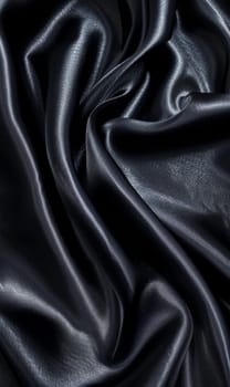 Luxe black satin fabric captured in undulating waves, creating a sense of movement