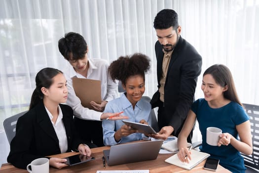 Happy diverse business people work together, discussing in corporate office. Professional and diversity teamwork discuss business plan on desk with laptop. Modern multicultural office worker. Concord