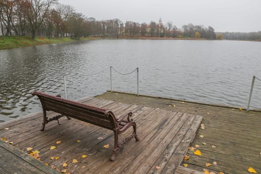 Wooden pier on the background of the lake, autumn. Place for fishing, rural recreation, camping.