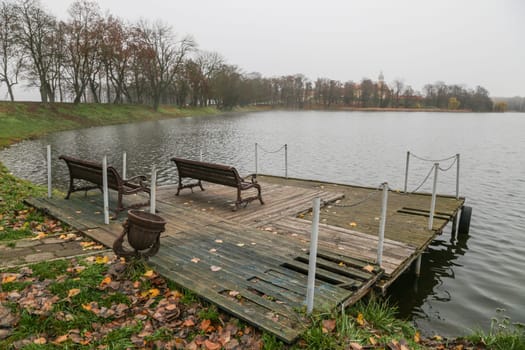 The benches on the wooden village pier. A place to rest on the bank of the river.