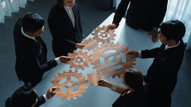 Top view of business people gather wooden cog together at meeting. Group of project manager helping and team working to solve problem at meeting room or workplace. Represent unity. Directorate.