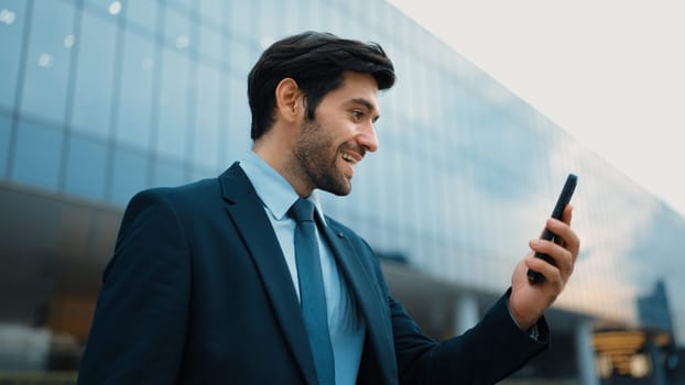 Successful business man celebrate increasing sales while standing. Happy project manager or leader proud with successful project, getting a promotion, getting a job while holding a phone. Exultant.