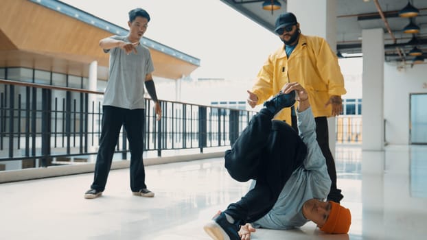 Hip hop team dance break dance while multicultural friend surrounded and clapping hands to cheer or encourage his friend to dance. Active and energetic street dance. Outdoor sport 2024. Endeavor.