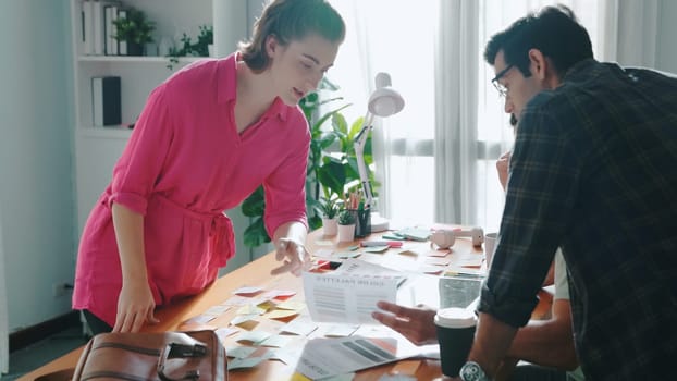 Skilled caucasian business woman present theme color to diverse investor. Multicultural people planning and making decision for choosing color for product while sitting at meeting table. Symposium.