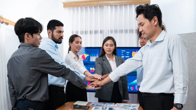 Multiracial office worker's hand stack shows solidarity, teamwork and trust in diverse community. Businesspeople unite for business success through synergy and collaboration by hand stacking. Concord