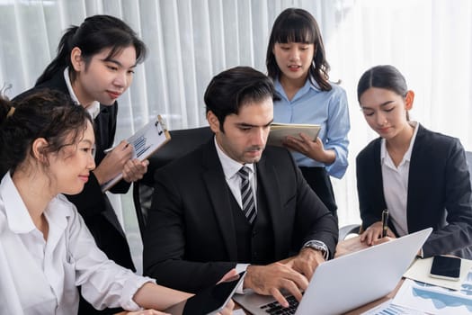 Diverse group of business analyst team analyzing financial data report paper on office table. Chart and graph dashboard by business intelligence analysis for strategic marketing planning Meticulous