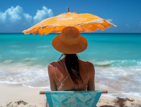 Woman relaxing on a beach chair under an umbrella by the turquoise sea.